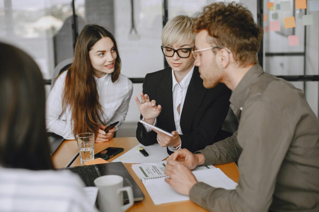 Professional team collaborating in a modern office meeting room, discussing strategies.